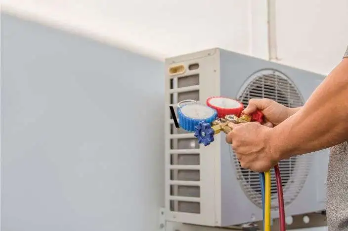 Technician checking air conditioner gas pressure with manifold gauge, AC gas refill service, air conditioning maintenance Dubai