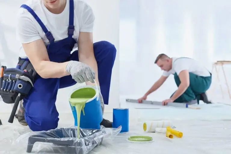 Professional painters preparing green paint for interior wall painting, home painting services in Dubai, renovation and maintenance work in progress