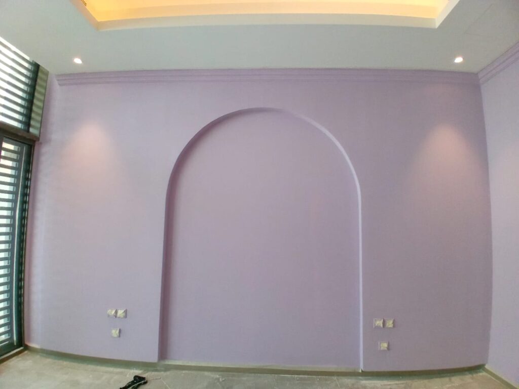 Interior wall painted in soft lavender color with an arched design, part of professional villa painting services in Dubai.